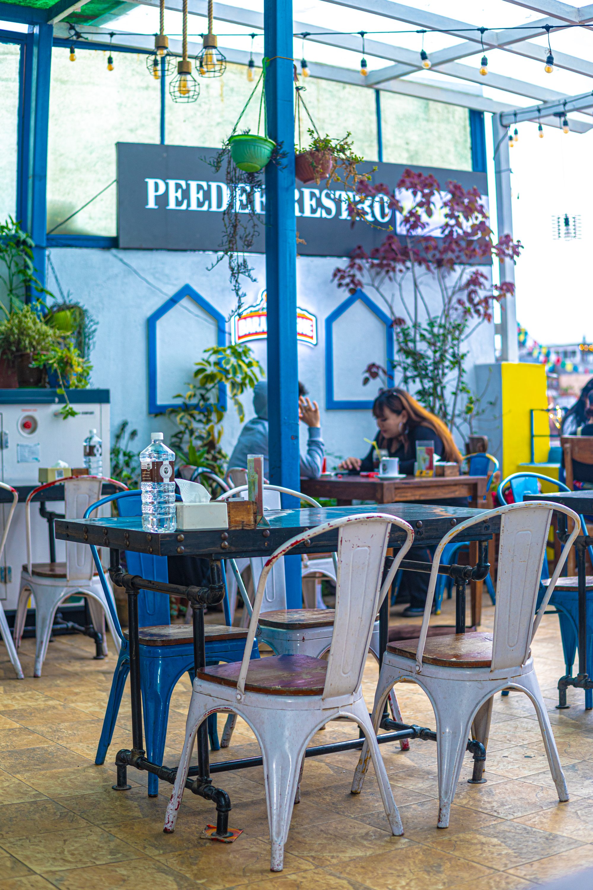 Rooftop seating with prayer flags and warm string lights